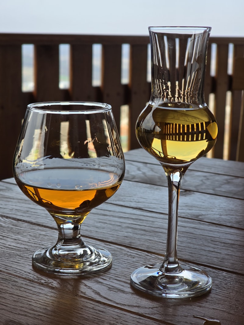 Deux verres de Bas-Armañac posés sur une table en madera